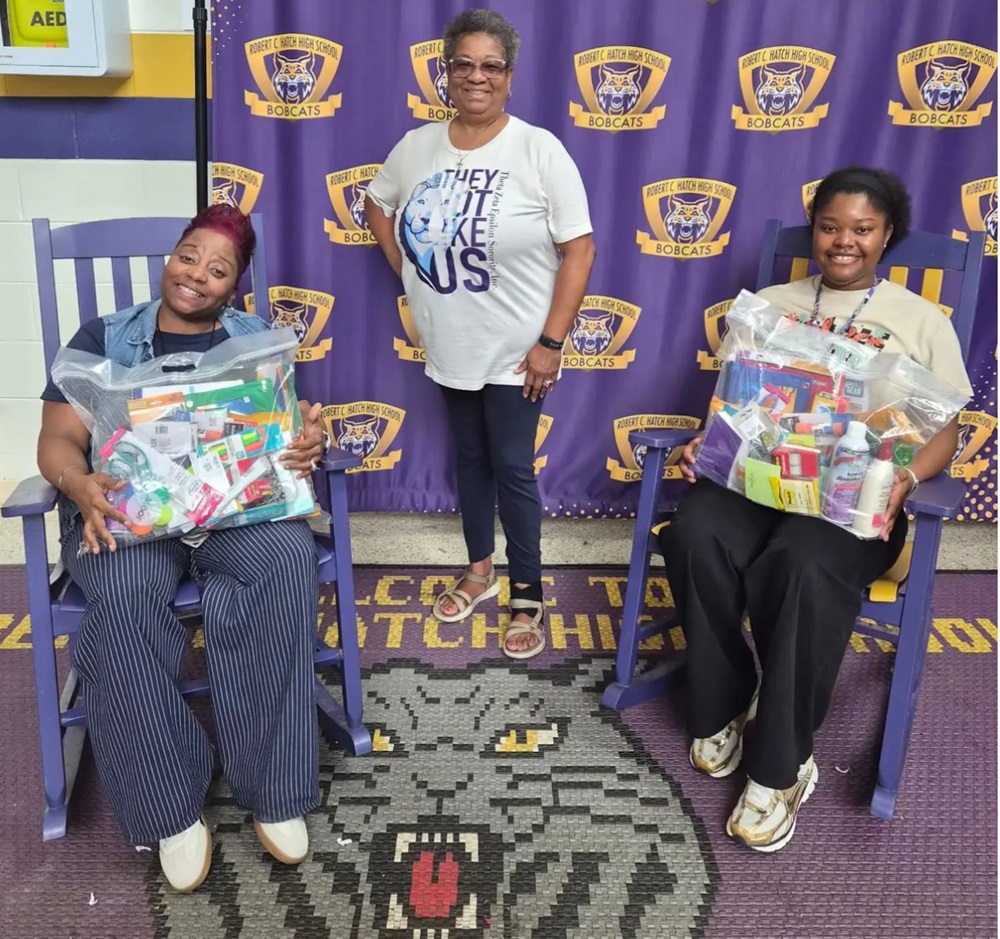 Brenda Cooke of Theta Zeta Epsilon, center, with classroom supplies donated to Robert C. Hatch High School teachers