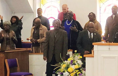 Pastor Williams and choir members at recent Thanksgiving program during congregational song.
