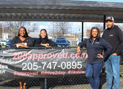 Mr. Erek Yarbrough, Mrs. Yarbrough and staff smile for the camera.
