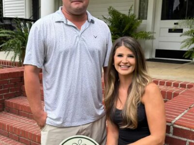 Chad and Kimberly Milner with the Greensboro Garden Club’s Yard of the Month sign at their College Street home.